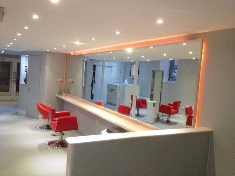 The salon’s long mirrored styling bar with red chairs
